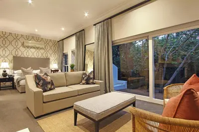 a living room with a couch and a bedroom at Stellenbosch Manor in Stellenbosch