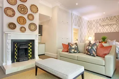a living room with a couch and a fireplace at Stellenbosch Manor in Stellenbosch