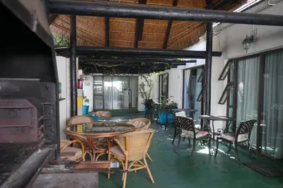 a patio with a table and chairs and a fireplace at Peak Village Lodge in Bloubergstrand