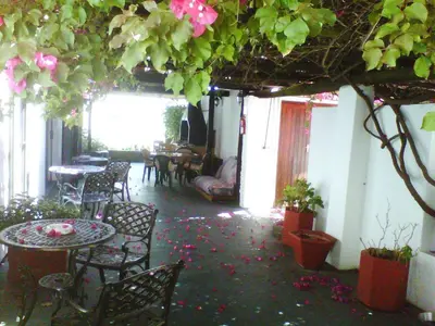 a room with tables and chairs and flowers on the floor at Peak Village Lodge in Bloubergstrand