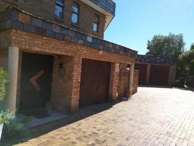 a brick building with two garage doors and a brick driveway at Ville la'Rina in Cape Town