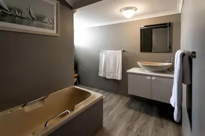 a bathroom with a tub and a sink at Son & Saffier in Hermanus