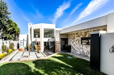 a large white house with a stone facade at Serendipity in Hermanus