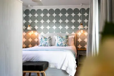 a bedroom with a bed and a wall with pillows at Serendipity in Hermanus