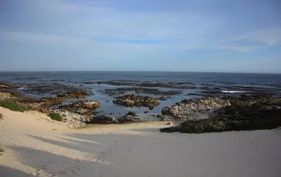 an aerial view of a beach with rocks and the ocean at Bietou on the Sea in Hermanus