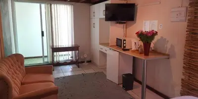 a kitchen with a couch and a table with a microwave at Lodge Strand (The) in Strand