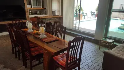 a dining room with a wooden table and chairs at Lodge Strand (The) in Strand