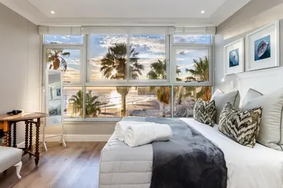 a bedroom with a bed and a large window at Ashley on Beach Strand in Strand