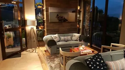 a living room with couches and a table at Bay View Guest House in Somerset West