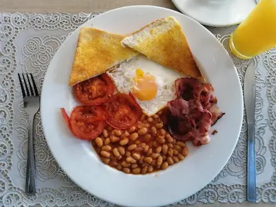 a plate of breakfast food with eggs bacon beans and toast at Onyx on Sycamore in Cape Town