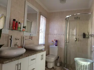 a bathroom with a shower and a toilet and a sink at Onyx on Sycamore in Cape Town