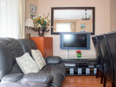 a living room with a leather couch and a television at Onyx on Sycamore in Cape Town