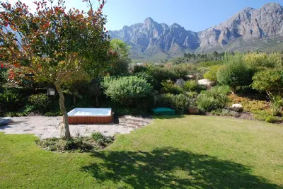 a garden with a hot tub in the middle of a yard at Kingsbury Cottage in Breerivier