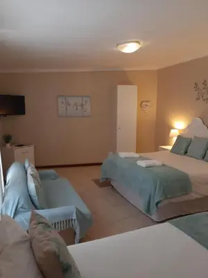 a living room with two beds and a couch at On Yonder Hill in Cape Town