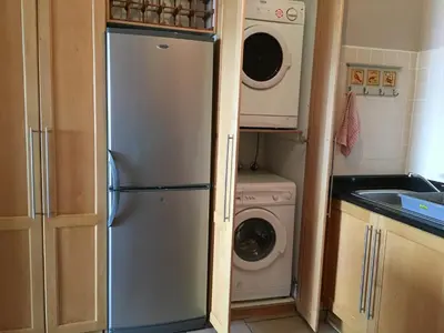 a kitchen with a refrigerator and a washer and dryer at C-Rus in Strand
