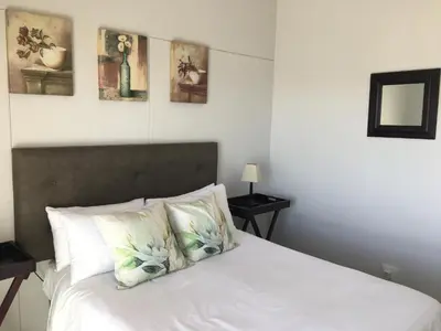 a bedroom with a white bed with two pillows at C-Rus in Strand