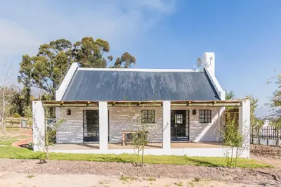 a small white house with a metal roof at Druk My Niet Wine Estate in Paarl