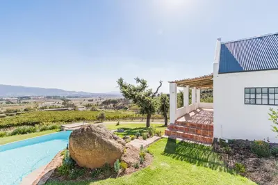 a house with a swimming pool next to a building at Druk My Niet Wine Estate in Paarl
