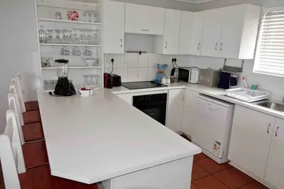 a kitchen with white cabinets and a white counter top at Whales & Waves in Hermanus