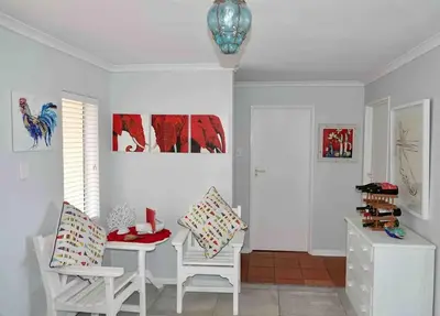 a white room with two chairs and a table at Whales & Waves in Hermanus
