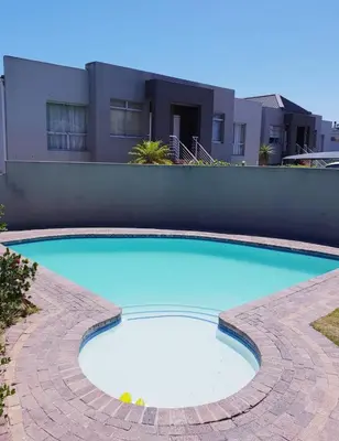 a large blue swimming pool in front of a building at D'urban Ridge Self catering Apartment in Cape Town