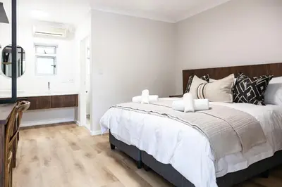a bedroom with a large bed and a window at Skinkikofi Guest House in Paarl