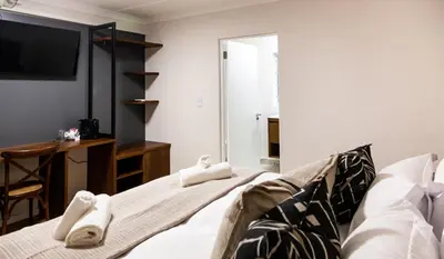 a room with a bed with towels on it at Skinkikofi Guest House in Paarl
