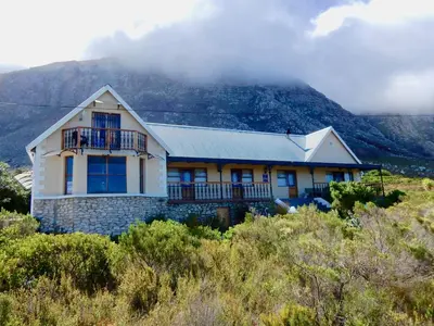 a house on top of a hill with a mountain at Mountain Mist in Bettyʼs Bay