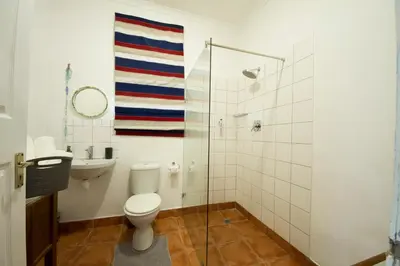a bathroom with a toilet and a shower and a sink at @Abelia Guest House in Somerset West