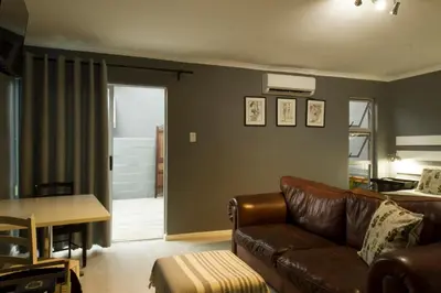a living room with a couch and a table at @Abelia Guest House in Somerset West