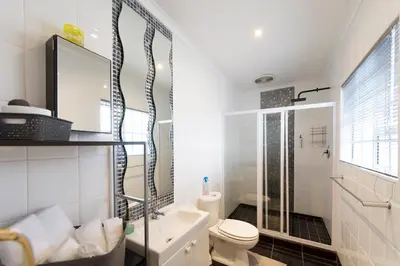 a white bathroom with a toilet and a sink at @Abelia Guest House in Somerset West