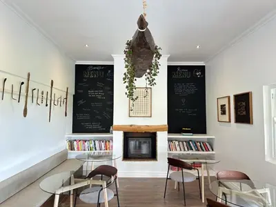 a restaurant with two tables and chairs and a chalkboard at Huguenot House in Franschhoek