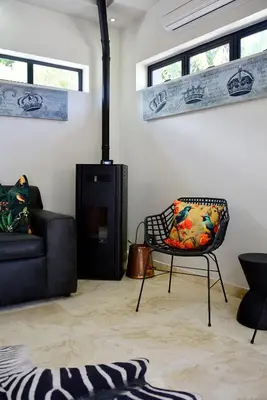 a living room with a couch and a chair at Crown Comfort - Affordable luxury - Private Heated Pool & Hot Tub Under Roof in Cape Town