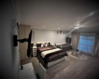 a bedroom with a bed and a television in it at Ridgeworth, Tygervalley in Cape Town
