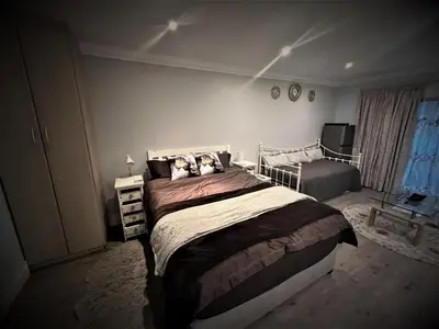 a bedroom with a large bed and a window at Ridgeworth, Tygervalley in Cape Town