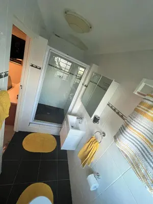 a bathroom with a toilet and a sink and a window at Ridgeworth, Tygervalley in Cape Town