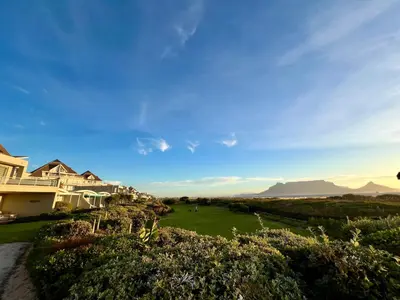 a view of a house with mountains in the background at Dolphin Beach Cabana in Table View