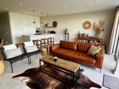 a living room with a couch and chairs and a table at Dolphin Beach Cabana in Table View