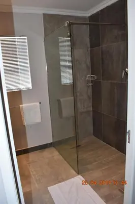 a shower with a glass door in a bathroom at Pringle Nest in Cape Town