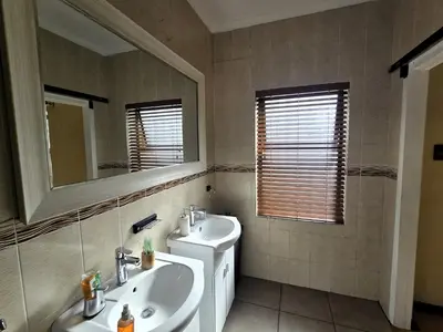 a bathroom with a sink and a mirror at Walters Lane Luxury Accommodation main house - No loadshedding in Cape Town