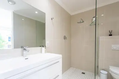 a bathroom with a sink and a toilet and a mirror at Koetsiershuis in Stellenbosch