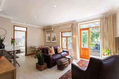 a living room with a couch and a table at Koetsiershuis in Stellenbosch