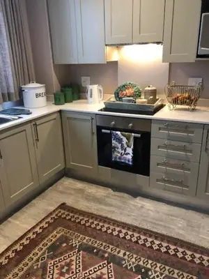 a kitchen with white cabinets and an oven at The Lemon Tree in Franschhoek in Franschhoek