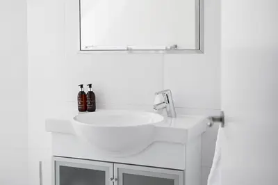 a white bathroom with a sink and a mirror at No. 6 The Yard in Franschhoek