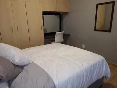 a bedroom with a white bed and a desk at TwinnPalms Accommodation in Cape Town