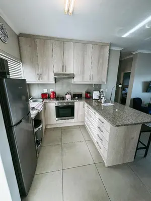 a kitchen with a refrigerator and a counter top at Nemesia Court in Durbanville