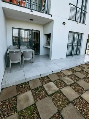 a patio with a table and chairs in a building at Nemesia Court in Durbanville