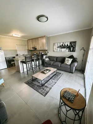 a living room with a couch and a table at Nemesia Court in Durbanville