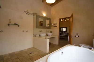 a bathroom with a tub and a sink and a mirror at Rouxwil Country House in Caledon