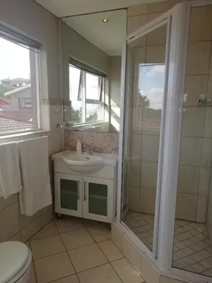 a bathroom with a shower and a sink and a toilet at Maroela House Guest Accommodation in Bellville
